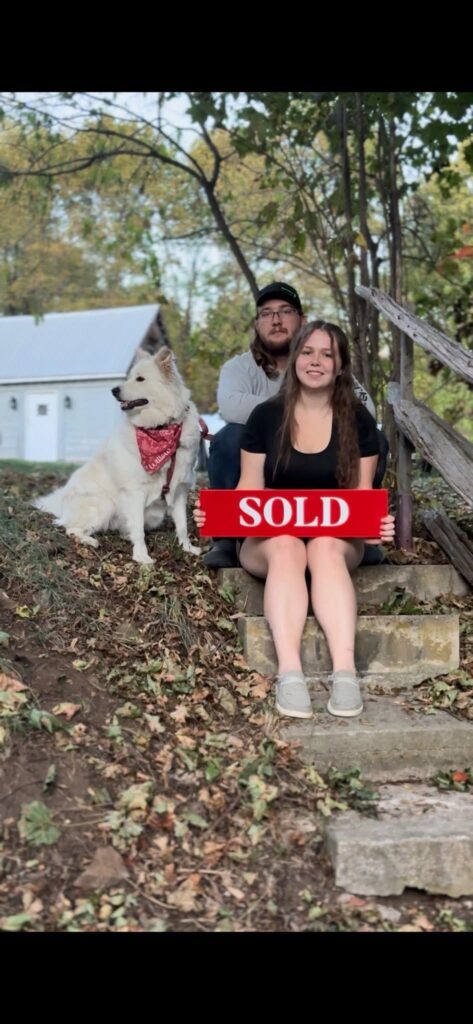 Family celebrating home purchase with SOLD sign Ottawa Valley
